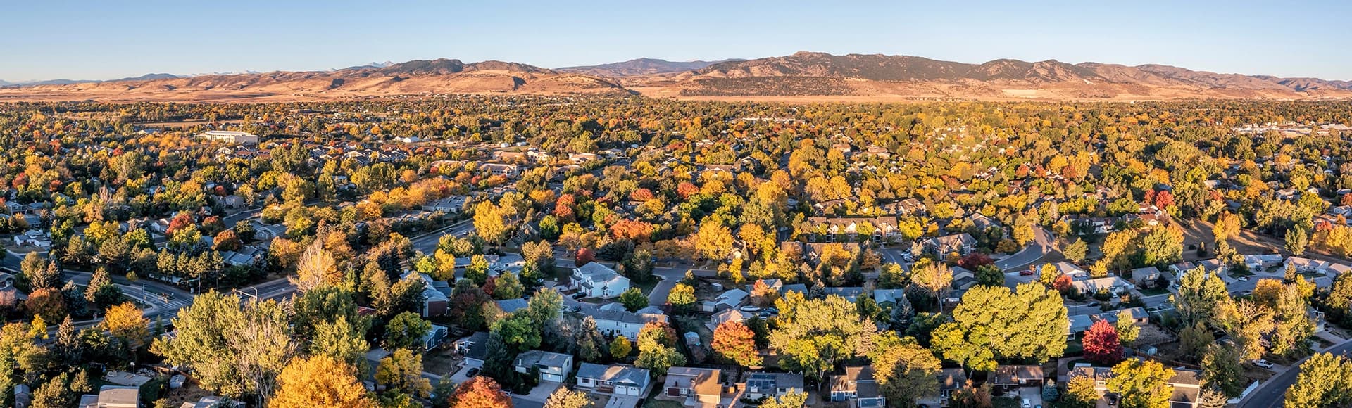 City of Fort Collins (residential area) and Front Range of Rocky Mountains in northern Colorado, aerial panorama in fall scenery